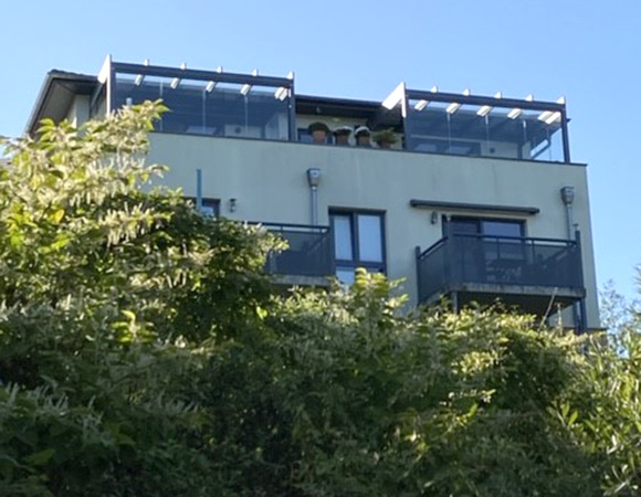 Dachterrasse mit Terrazza Pure in anthrazit mit Glasschiebewänden und Megawood Bodenbelag