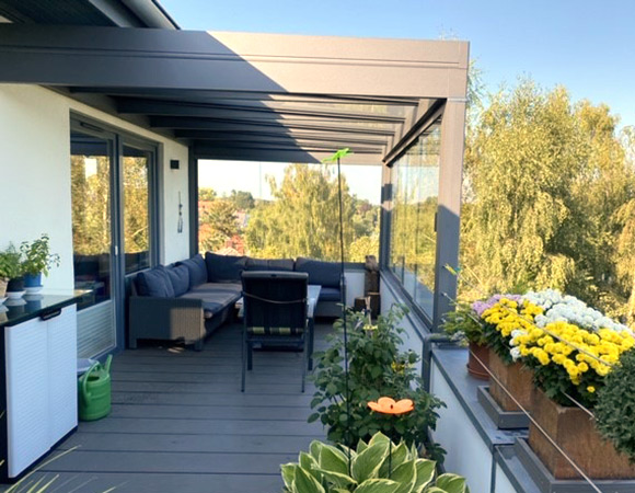 Dachterrasse mit Terrazza Pure in anthrazit mit Glasschiebewänden und Megawood Bodenbelag