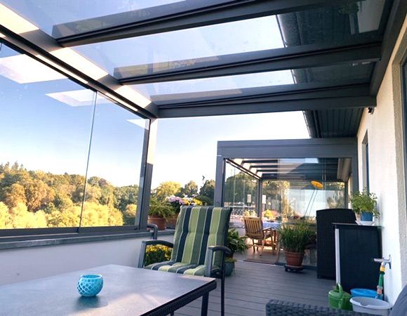 Dachterrasse mit Terrazza Pure in anthrazit mit Glasschiebewänden und Megawood Bodenbelag